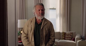 Movie still from “The Meyerowitz Stories” (2017), directed by Noah Baumbach – An older man with a gray beard standing in front of a window; Medium shot, Over the shoulder angle