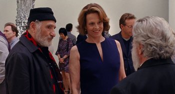 Movie still from “The Meyerowitz Stories” (2017), directed by Noah Baumbach – A woman in a blue dress standing next to an older man; Medium shot, Over the shoulder angle