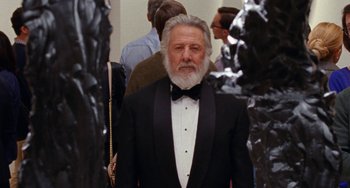 Movie still from “The Meyerowitz Stories” (2017), directed by Noah Baumbach – An older man in a tuxedo standing in front of a group of people; Medium shot, Low angle