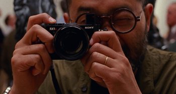 Movie still from “The Meyerowitz Stories” (2017), directed by Noah Baumbach – A man taking a picture with a camera; Extreme Close Up shot, Overhead angle