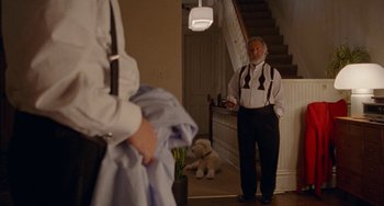 Movie still from “The Meyerowitz Stories” (2017), directed by Noah Baumbach – An older man standing in front of a staircase; Wide shot, Over the shoulder angle