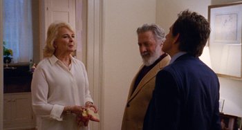 Movie still from “The Meyerowitz Stories” (2017), directed by Noah Baumbach – Two men and a woman standing next to each other in a room; Medium shot, Over the shoulder angle