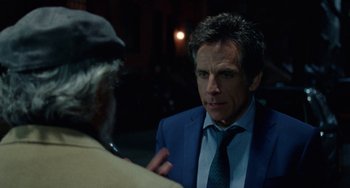 Movie still from “The Meyerowitz Stories” (2017), directed by Noah Baumbach – A man wearing a suit and tie talking to another man wearing a hat; Close Up shot, Over the shoulder angle