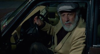Movie still from “The Meyerowitz Stories” (2017), directed by Noah Baumbach – An older man sitting in a car with a steering wheel; Close Up shot, High angle