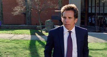 Movie still from “The Meyerowitz Stories” (2017), directed by Noah Baumbach – A man in a suit and tie standing in the grass; Medium shot, Over the shoulder angle