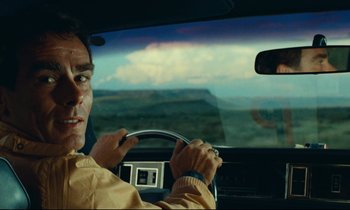 Movie still from “Paris, Texas” (1984), directed by Wim Wenders – A man driving a car in the middle of the day; Close Up shot, Over the shoulder angle