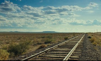 Movie still from “Paris, Texas” (1984), directed by Wim Wenders – A train track in the middle of a field; Extreme Wide shot, Low angle