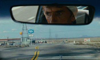Movie still from “Paris, Texas” (1984), directed by Wim Wenders – A man looking out of the window of a car; Close Up shot, Over the shoulder angle