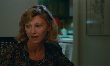 Movie still from “Paris, Texas” (1984), directed by Wim Wenders – A woman sitting in front of a kitchen counter; Close Up shot, Over the shoulder angle