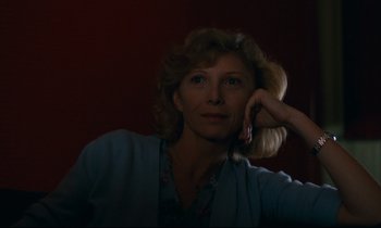 Movie still from “Paris, Texas” (1984), directed by Wim Wenders – A woman is sitting in the dark with her hand on her face; Close Up shot, Low angle