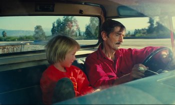 Movie still from “Paris, Texas” (1984), directed by Wim Wenders – A man sitting next to a little girl in the back of a car; Medium shot, Over the shoulder angle