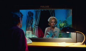 Movie still from “Paris, Texas” (1984), directed by Wim Wenders – A woman is looking into a mirror at the pool side; Medium shot, Over the shoulder angle