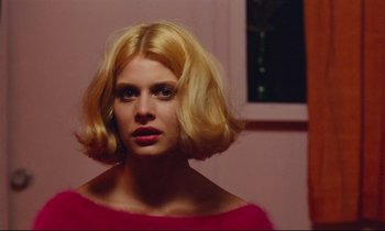 Movie still from “Paris, Texas” (1984), directed by Wim Wenders – A woman with blonde hair is looking at the camera; Close Up shot, Over the shoulder angle