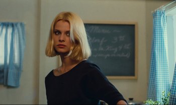 Movie still from “Paris, Texas” (1984), directed by Wim Wenders – A woman standing in front of a chalkboard; Close Up shot, Over the shoulder angle