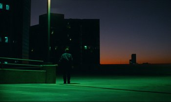 Movie still from “Paris, Texas” (1984), directed by Wim Wenders – A man standing on a rooftop at night; Extreme Wide shot, Low angle
