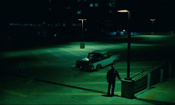 Movie still from “Paris, Texas” (1984), directed by Wim Wenders – A man standing in a parking lot next to a car; Extreme Wide shot, High angle