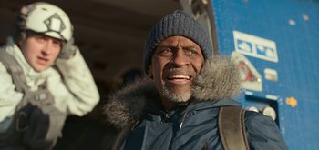 Movie still from “The Midnight Sky” (2020), directed by George Clooney – An older man wearing a winter coat and a hat; Close Up shot, Low angle