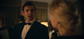 Movie still from “The Midnight Sky” (2020), directed by George Clooney – A man in a tuxedo talking to a woman in front of a christmas tree; Close Up shot, Over the shoulder angle