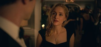 Movie still from “The Midnight Sky” (2020), directed by George Clooney – A beautiful blonde woman wearing a black dress; Close Up shot, Over the shoulder angle