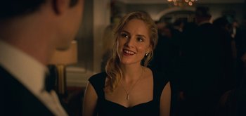 Movie still from “The Midnight Sky” (2020), directed by George Clooney – A woman in a black dress smiling for the camera; Close Up shot, Over the shoulder angle