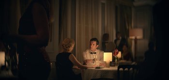 Movie still from “The Midnight Sky” (2020), directed by George Clooney – A man and a woman sitting at a dinner table; Medium shot, Over the shoulder angle