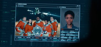 Movie still from “The Midnight Sky” (2020), directed by George Clooney – A computer screen showing a group of people in spacesuits; Medium shot, Overhead angle