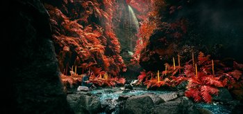 Movie still from “The Midnight Sky” (2020), directed by George Clooney – A person sitting on a rock near a waterfall; Extreme Wide shot, High angle