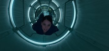 Movie still from “The Midnight Sky” (2020), directed by George Clooney – A woman in a tunnel looking up at the camera; Medium shot, Overhead angle