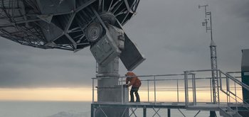 Movie still from “The Midnight Sky” (2020), directed by George Clooney – A man standing on top of a platform next to an antenna; Extreme Wide shot, Low angle