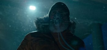 Movie still from “The Midnight Sky” (2020), directed by George Clooney – A man with a gas mask on in the dark; Close Up shot, Low angle