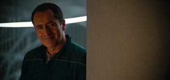 Movie still from “The Midnight Sky” (2020), directed by George Clooney – A man standing in front of a mirror smiling for the camera; Close Up shot, Over the shoulder angle