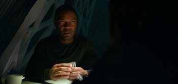 Movie still from “The Midnight Sky” (2020), directed by George Clooney – A man sitting in front of a mirror holding a cell phone; Close Up shot, Over the shoulder angle