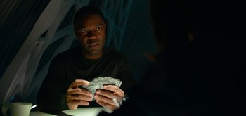 Movie still from “The Midnight Sky” (2020), directed by George Clooney – A man holding a bunch of money in his hands; Close Up shot, Over the shoulder angle