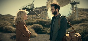 Movie still from “The Midnight Sky” (2020), directed by George Clooney – A man and a woman standing next to each other on a beach; Medium shot, Over the shoulder angle