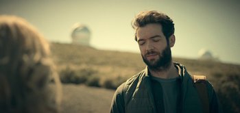 Movie still from “The Midnight Sky” (2020), directed by George Clooney – A man with a beard is standing in a field; Close Up shot, Low angle