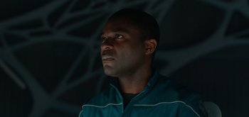 Movie still from “The Midnight Sky” (2020), directed by George Clooney – A man in a blue jacket looking up at the sky; Close Up shot, Low angle