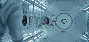 Movie still from “The Midnight Sky” (2020), directed by George Clooney – A person in a spacesuit inside a space station; Wide shot, Overhead angle