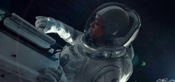 Movie still from “The Midnight Sky” (2020), directed by George Clooney – A person in a spacesuit is sitting in a space suit; Medium shot, Overhead angle
