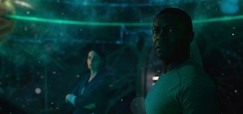 Movie still from “The Midnight Sky” (2020), directed by George Clooney – Two men are standing in a dark room; Medium shot, Over the shoulder angle