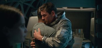 Movie still from “The Midnight Sky” (2020), directed by George Clooney – A man hugging another man in a space suit; Medium shot, Over the shoulder angle