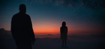 Movie still from “The Midnight Sky” (2020), directed by George Clooney – A woman standing on a hill looking at the stars; Extreme Wide shot, Low angle