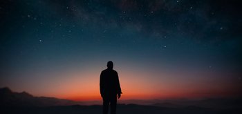 Movie still from “The Midnight Sky” (2020), directed by George Clooney – A man standing on a hill looking at the stars; Extreme Wide shot, Low angle