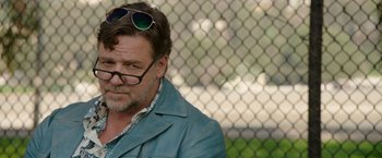 Movie still from “The Nice Guys” (2016), directed by Shane Black – A person wearing glasses and a jacket; Close Up shot, Over the shoulder angle