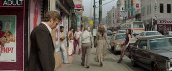 Movie still from “The Nice Guys” (2016), directed by Shane Black – A group of people walking down a sidewalk; Wide shot, Over the shoulder angle