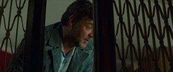 Movie still from “The Nice Guys” (2016), directed by Shane Black – A person leaning against a wall; Close Up shot, Low angle