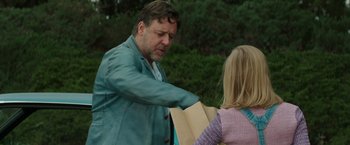 Movie still from “The Nice Guys” (2016), directed by Shane Black – A man and a woman holding a paper bag in a park; Medium shot, Over the shoulder angle
