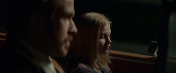 Movie still from “The Nice Guys” (2016), directed by Shane Black – A man and a woman sitting next to each other; Close Up shot, Over the shoulder angle