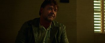 Movie still from “The Nice Guys” (2016), directed by Shane Black – A person sitting in a room; Close Up shot, Low angle