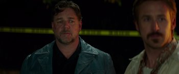 Movie still from “The Nice Guys” (2016), directed by Shane Black – A person wearing a leather jacket; Close Up shot, Over the shoulder angle