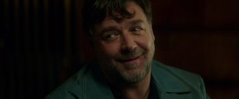 Movie still from “The Nice Guys” (2016), directed by Shane Black – A person with a beard smiling; Close Up shot, Over the shoulder angle